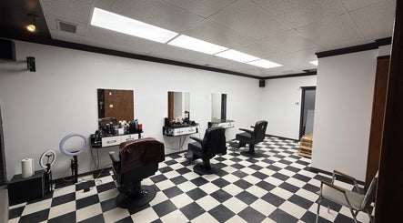 Interior of Carlos the barber, Medicine Hat, Alberta, CA, showing chic black and white décor with barber chairs.