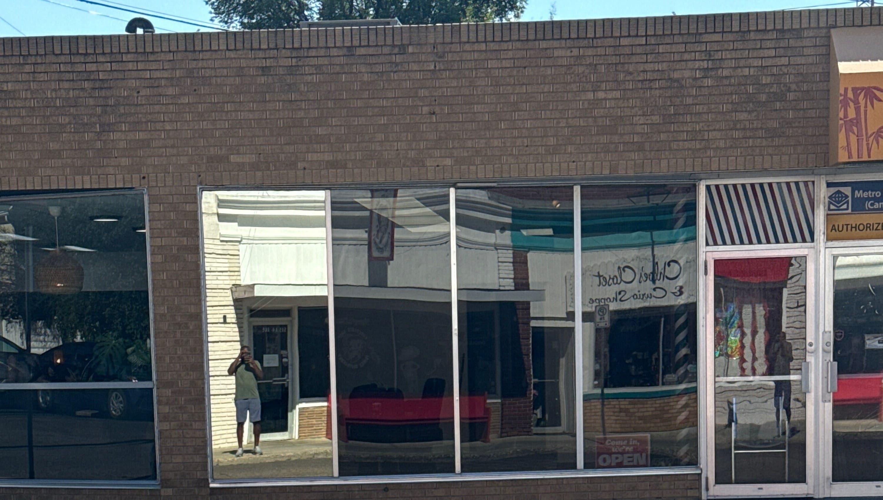 Front view of Goodfellas Barbershop showing reflections on windows. Carlos the barber in Medicine Hat, Alberta, CA.