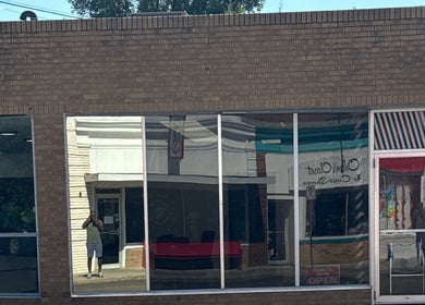 Front view of Goodfellas Barbershop showing reflections on windows. Carlos the barber in Medicine Hat, Alberta, CA.