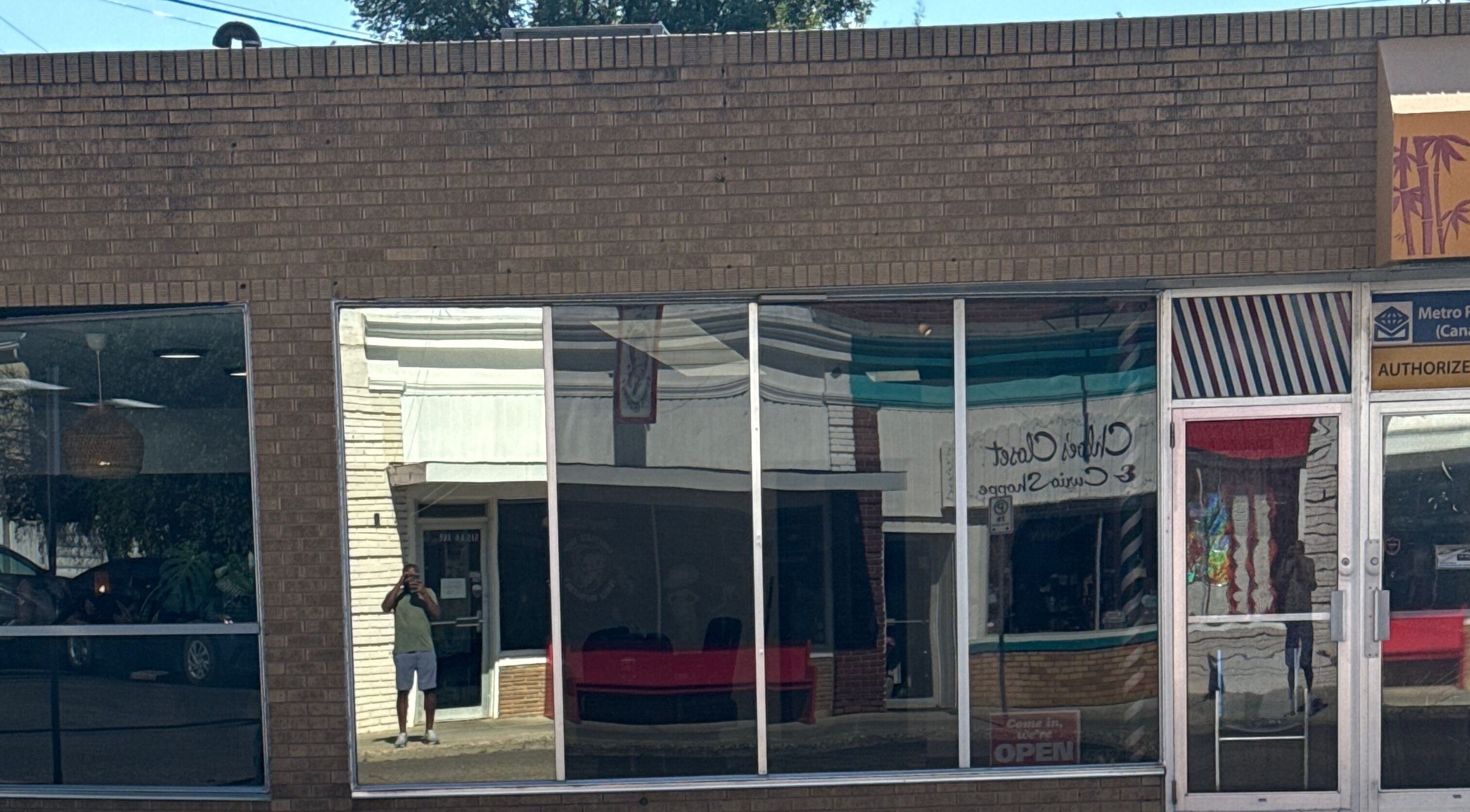 Front view of Goodfellas Barbershop showing reflections on windows. Carlos the barber in Medicine Hat, Alberta, CA.