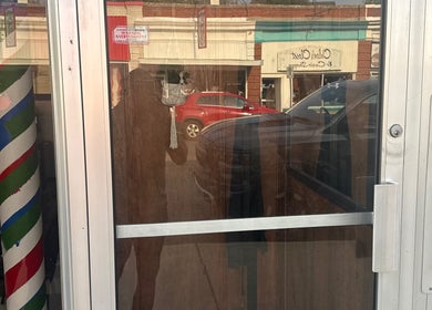 Entrance of Carlos the barber at Good Fellas Barbershop, Medicine Hat, Alberta, CA featuring a classic barber pole.