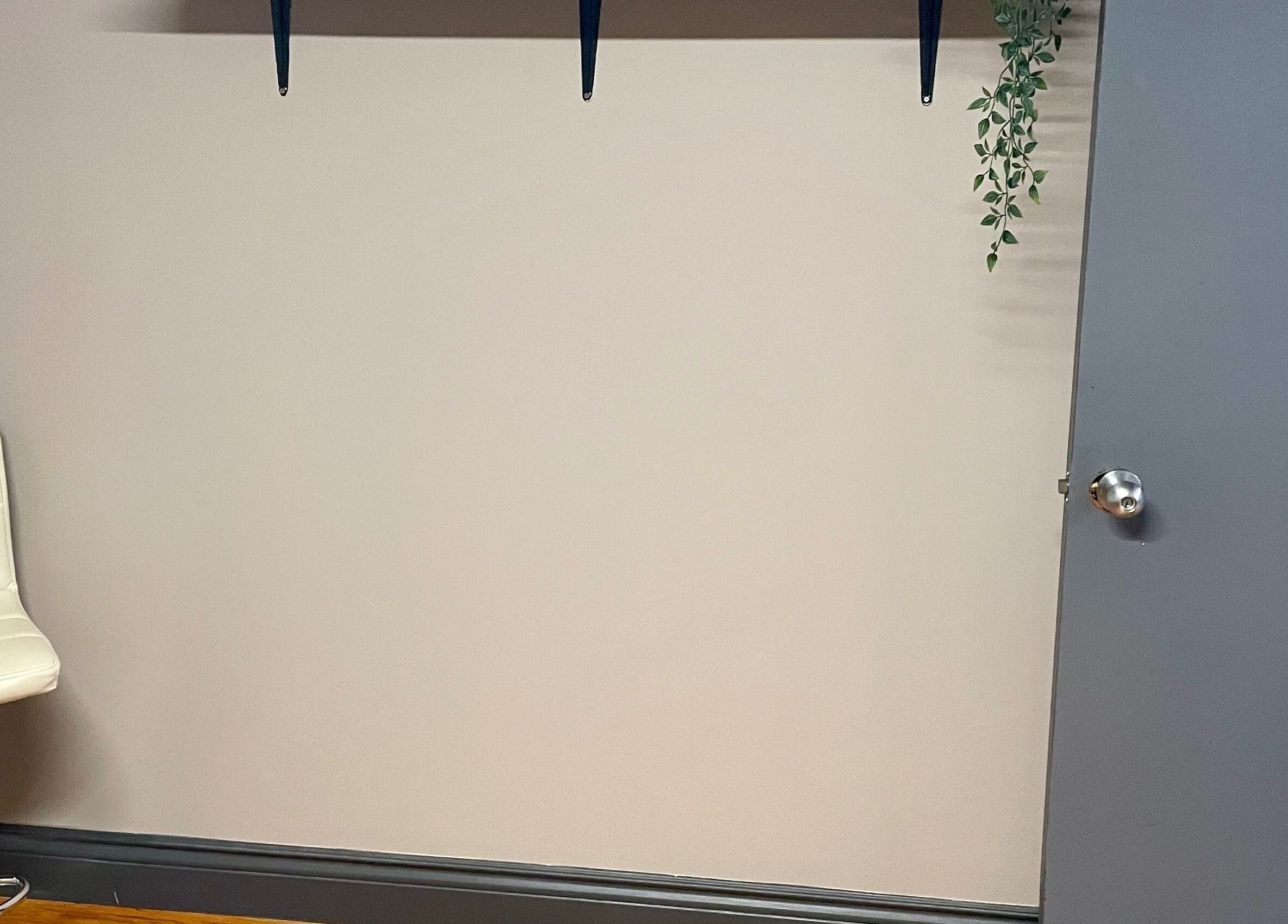 Minimalist white chair against wall at Velvet Eclipse, London, Ontario, CA.