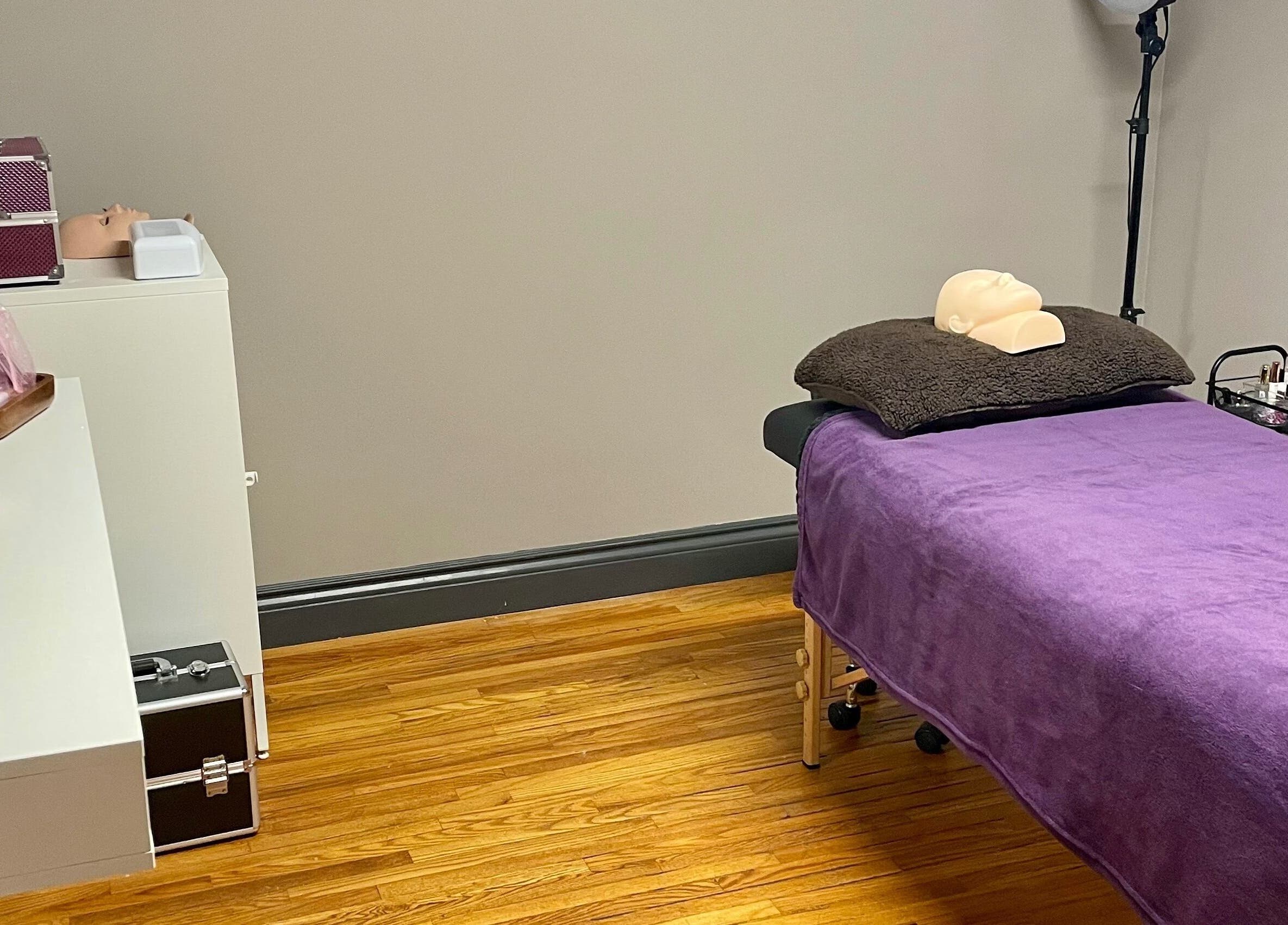 Calm treatment room at Velvet Eclipse in London, Ontario, CA with a purple bed and gentle lighting.