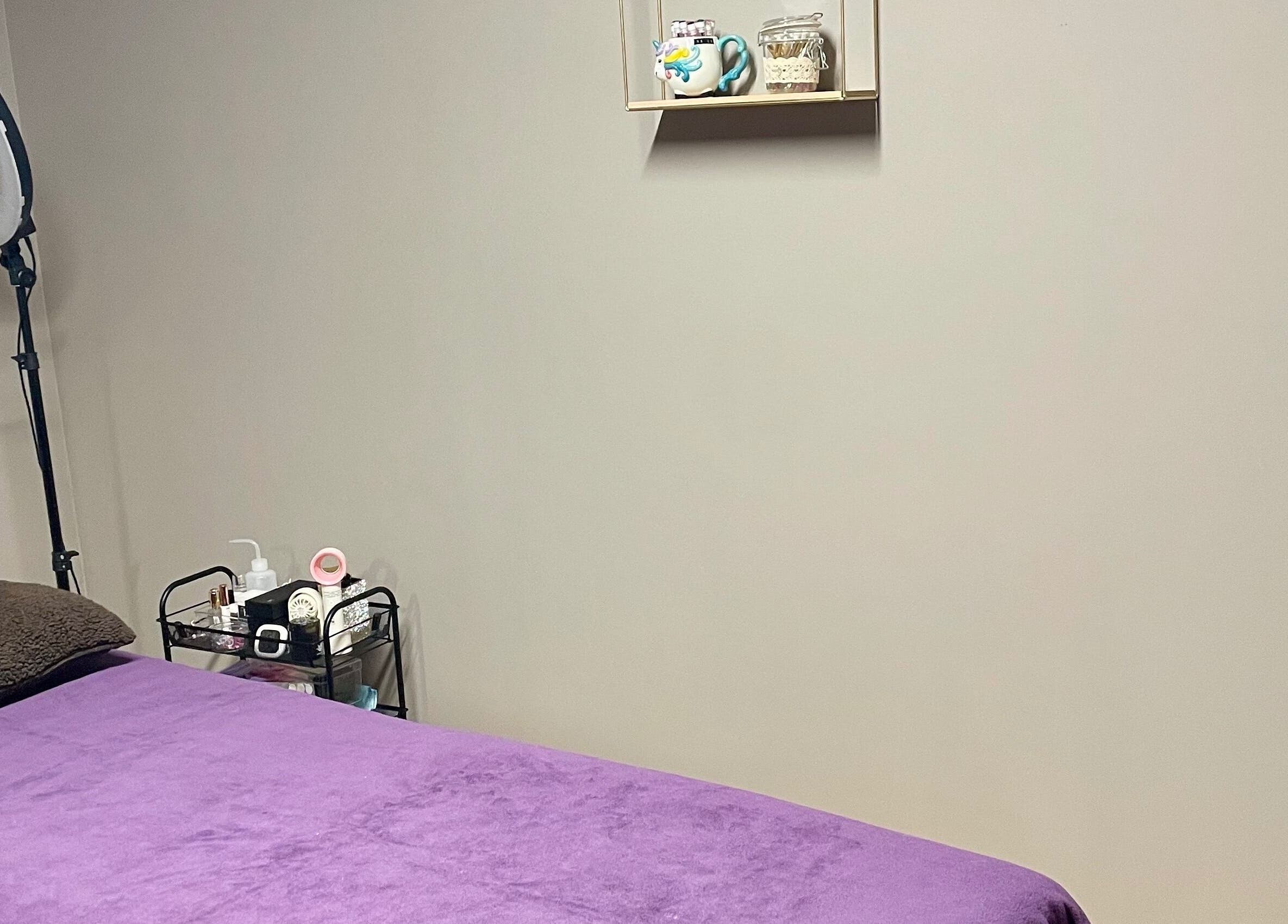 Massage room at Velvet Eclipse in London, Ontario, CA, featuring a purple bed and calming decor.
