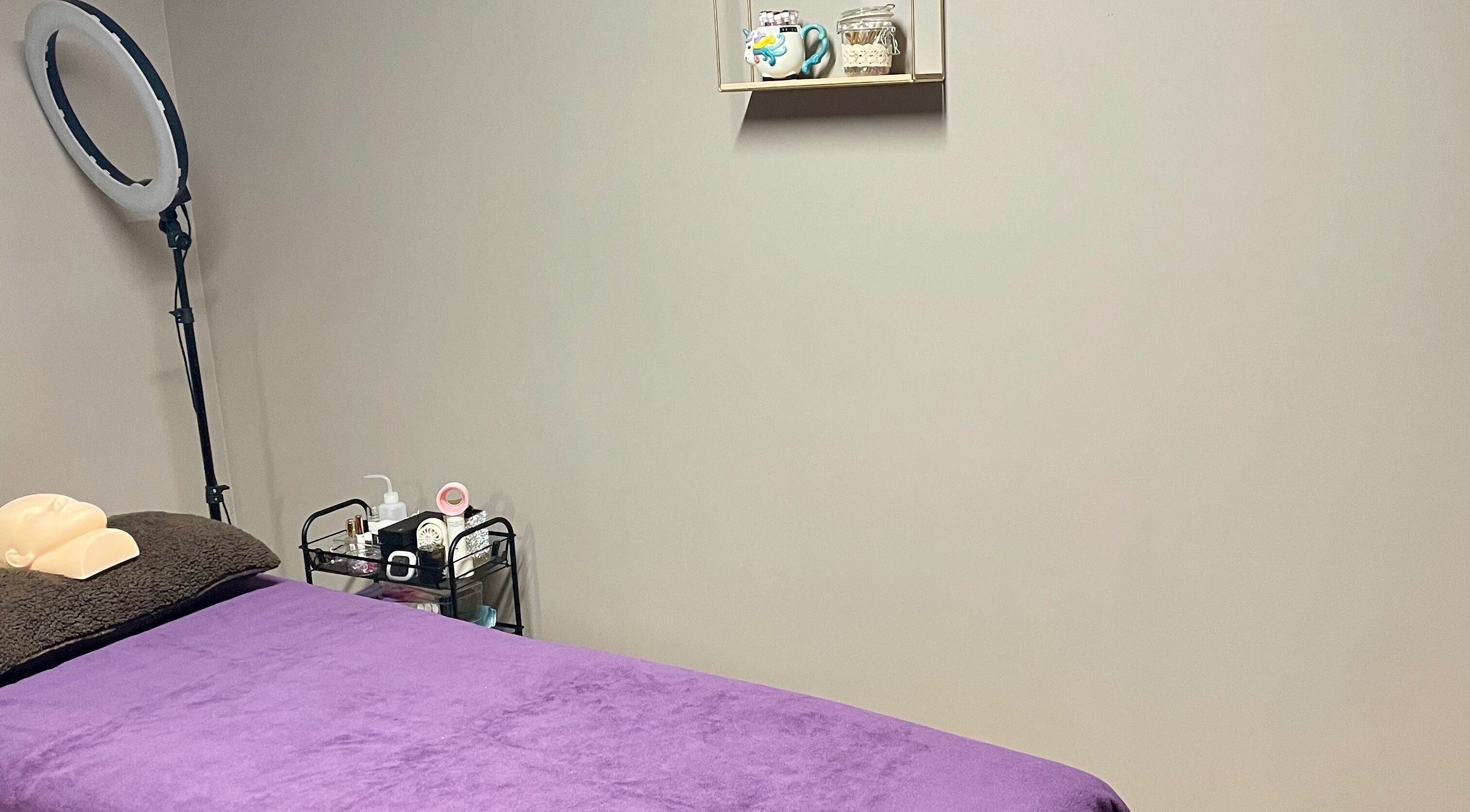 Massage room at Velvet Eclipse in London, Ontario, CA, featuring a purple bed and calming decor.