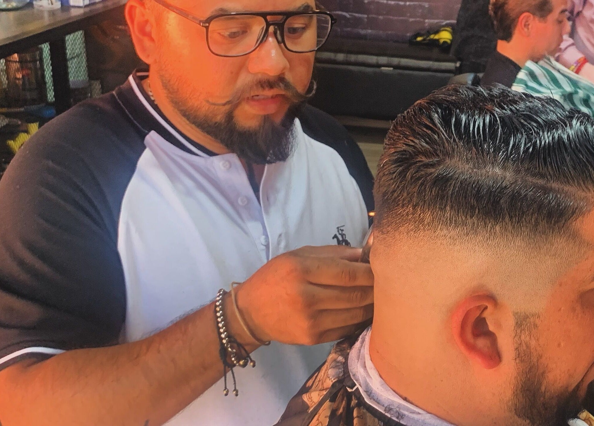 Barbero en Alta Peluqueria & Barberia HÉCTOR PARRA, Santiago De Querétaro, MX, realizando un corte preciso.