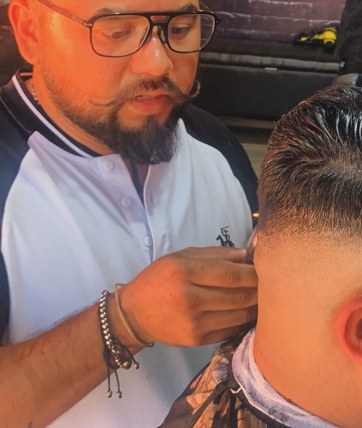 Barbero en Alta Peluqueria & Barberia HÉCTOR PARRA, Santiago De Querétaro, MX, realizando un corte preciso.