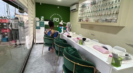 Interior do RJ Beauty Studio em Luanda, Luanda, AO, com cadeiras verdes e estante de esmaltes.