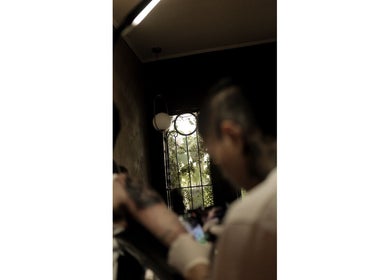 Interior view of ATMA TATTOO STUDIO in Mandaue, Central Visayas, PH, showing a tattoo artist at work.