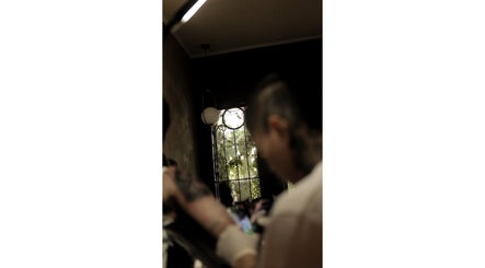 Interior view of ATMA TATTOO STUDIO in Mandaue, Central Visayas, PH, showing a tattoo artist at work.