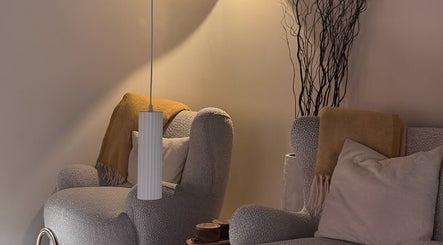 Relaxing seating area at SolBeauty Studio Newstead, Queensland, AU with plush chairs and warm lighting.