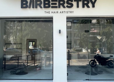 Εξωτερικό κατάστημα Barberstry στην Αθήνα, GR με πινακίδα και γυάλινη πρόσοψη.