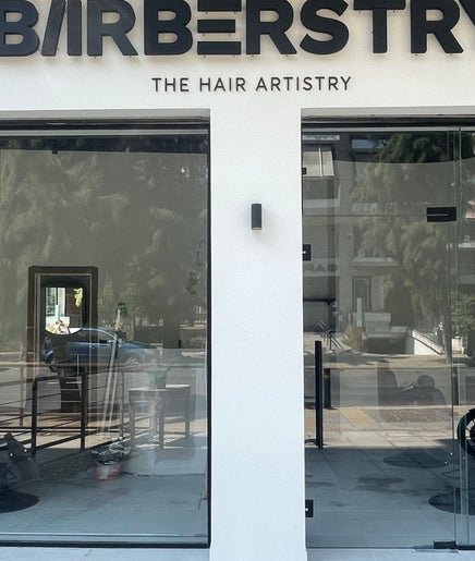 Εξωτερικό κατάστημα Barberstry στην Αθήνα, GR με πινακίδα και γυάλινη πρόσοψη.