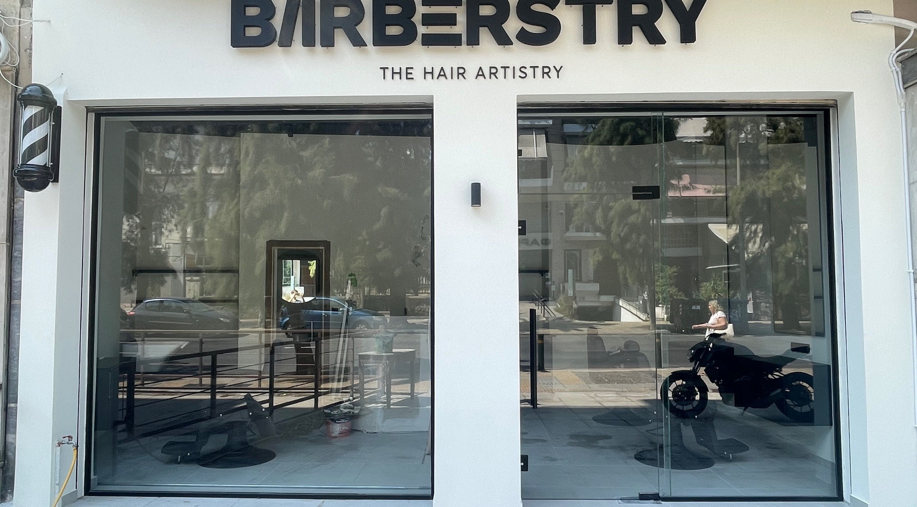Εξωτερικό κατάστημα Barberstry στην Αθήνα, GR με πινακίδα και γυάλινη πρόσοψη.