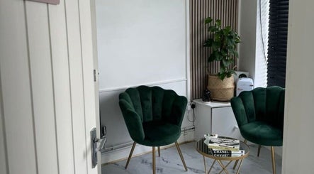 Cozy seating area at Revive Massage, Norwich, England, GB. Features plush green chairs and a stylish table.