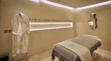 غرفة تدليك راقية في Code Barber&Spa، جدة، حائل، تحتوي على روب أبيض وطاولة تدليك.