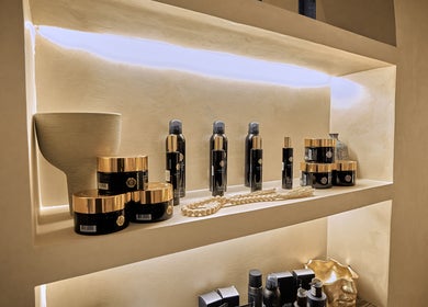 منتجات تجميل فاخرة على رفوف مضاءة في Code Barber&Spa بجدة، حائل، SA.