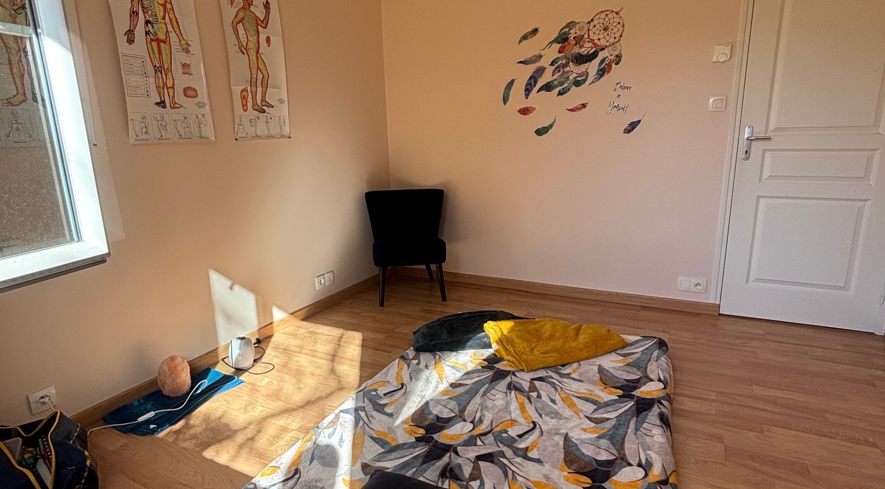 Salle de relaxation lumineuse chez Céline Roinson, Vitré, Bretagne, FR, avec tapis et décor mural apaisant.