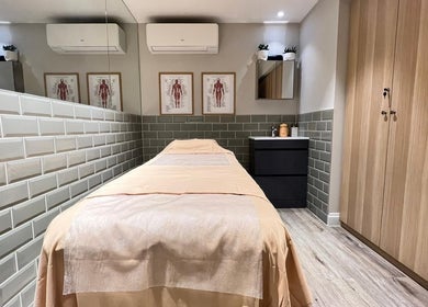 Relaxing massage room at AURA MASSAGE AND CUPPING CLINIC in London, England, GB, featuring a neatly prepared bed.