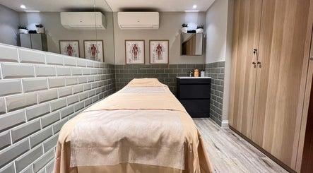 Relaxing massage room at AURA MASSAGE AND CUPPING CLINIC in London, England, GB, featuring a neatly prepared bed.