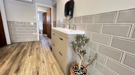 Elegant restroom at AURA MASSAGE AND CUPPING CLINIC, London, England, GB with modern finishes and plant decor.