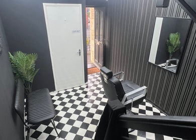 Modern interior of Rascal’s Barber Studio in Corby, England, GB, featuring checkered floor and sleek design.
