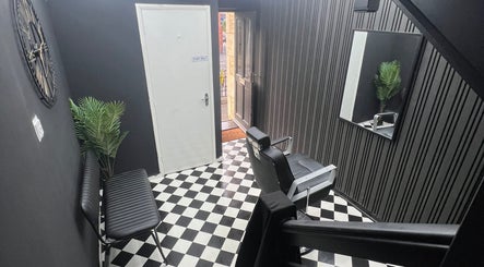 Modern interior of Rascal’s Barber Studio in Corby, England, GB, featuring checkered floor and sleek design.