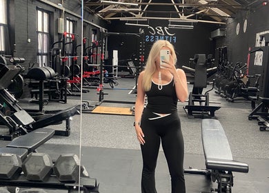 A modern gym interior at Evolve with Nicole, Denton, England, GB, featuring fitness equipment and a mirrored wall.