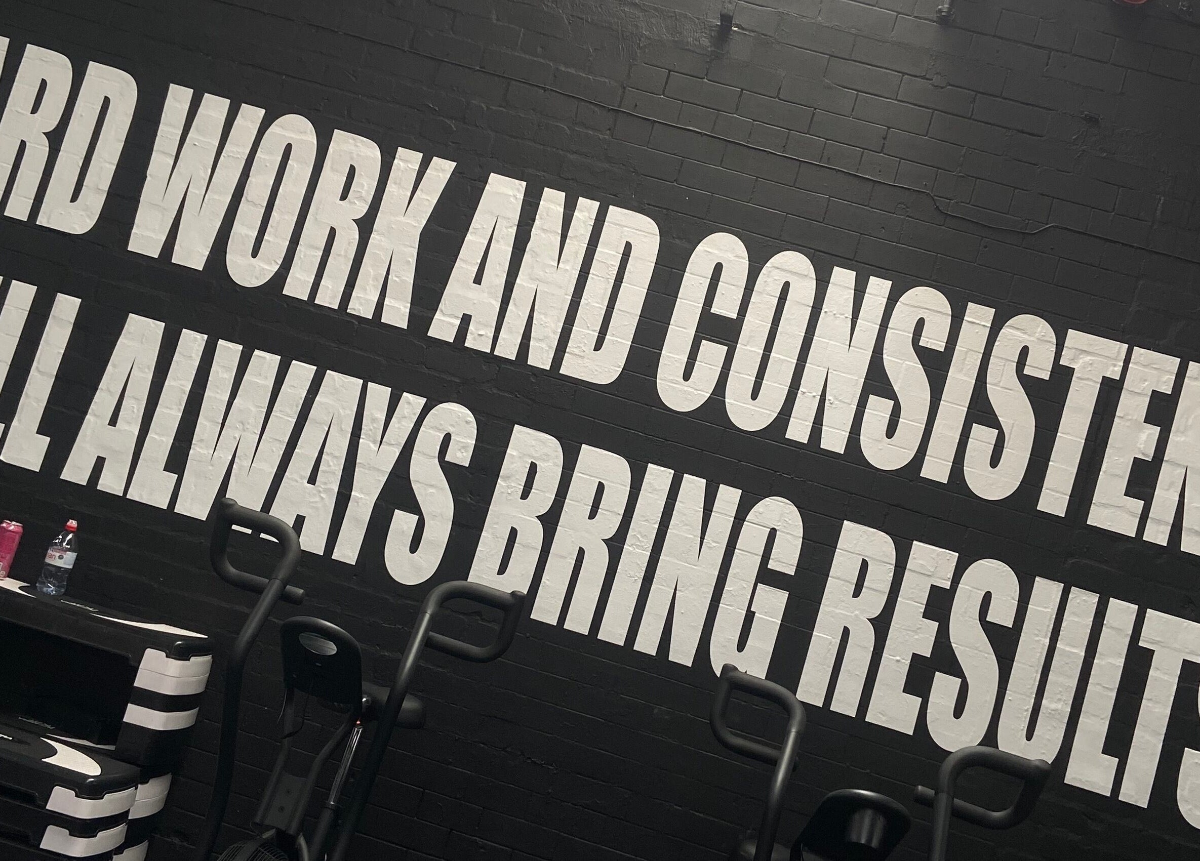 Evolve with Nicole in Denton, England showcases a motivational wall with 'Hard Work and Consistency' message.