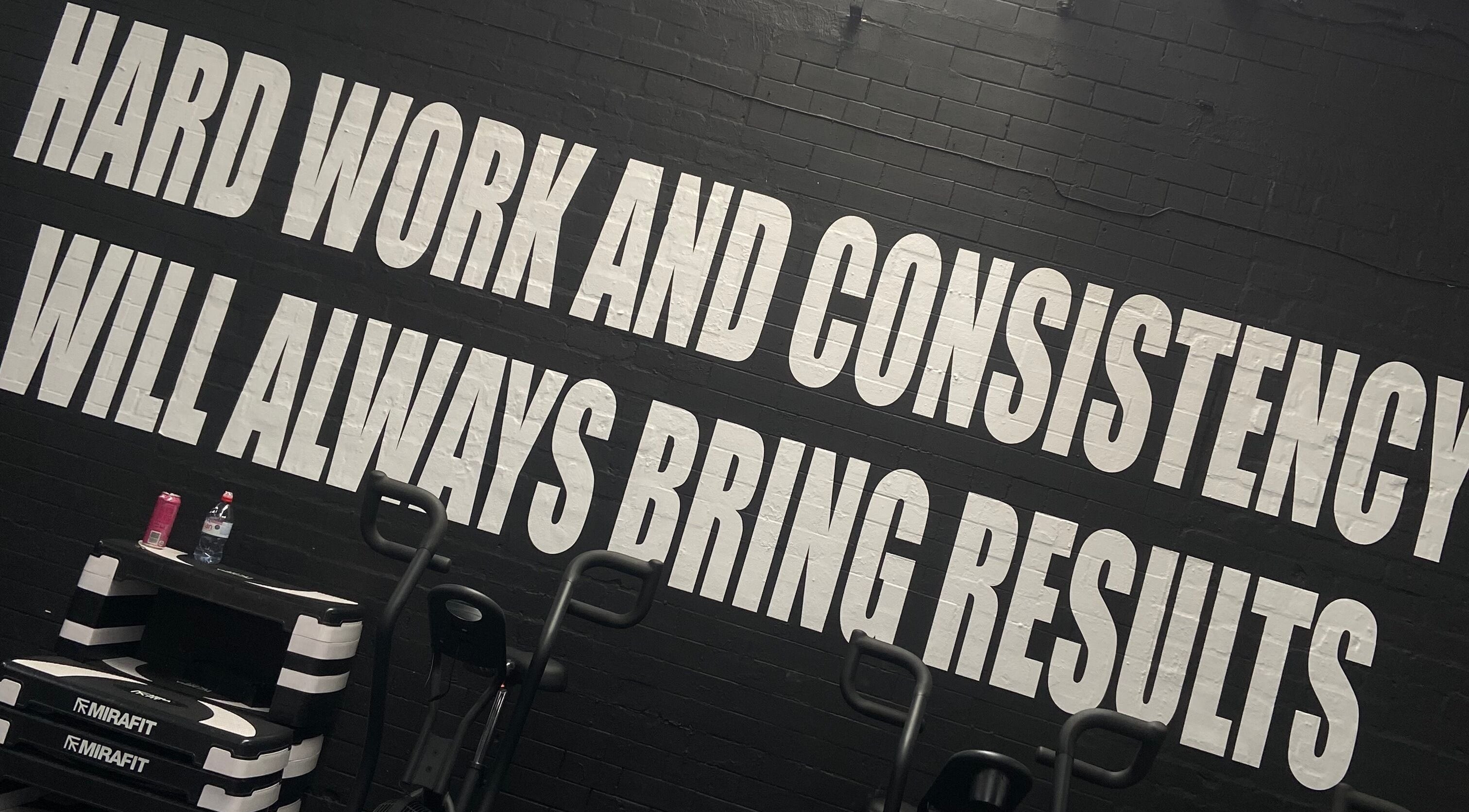 Evolve with Nicole in Denton, England showcases a motivational wall with 'Hard Work and Consistency' message.