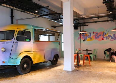 Colorful vintage truck in Queens LDN, London, England, GB cafe, enhancing a trendy and artistic atmosphere.