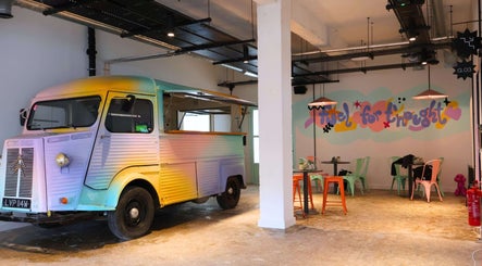 Colorful vintage truck in Queens LDN, London, England, GB cafe, enhancing a trendy and artistic atmosphere.