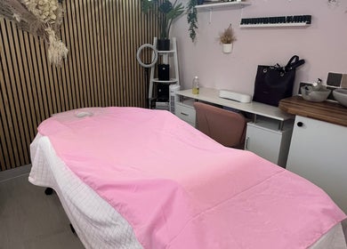 Peaceful massage room at Madame Massage, Portsmouth, England, GB, with pink decor and relaxing ambiance.