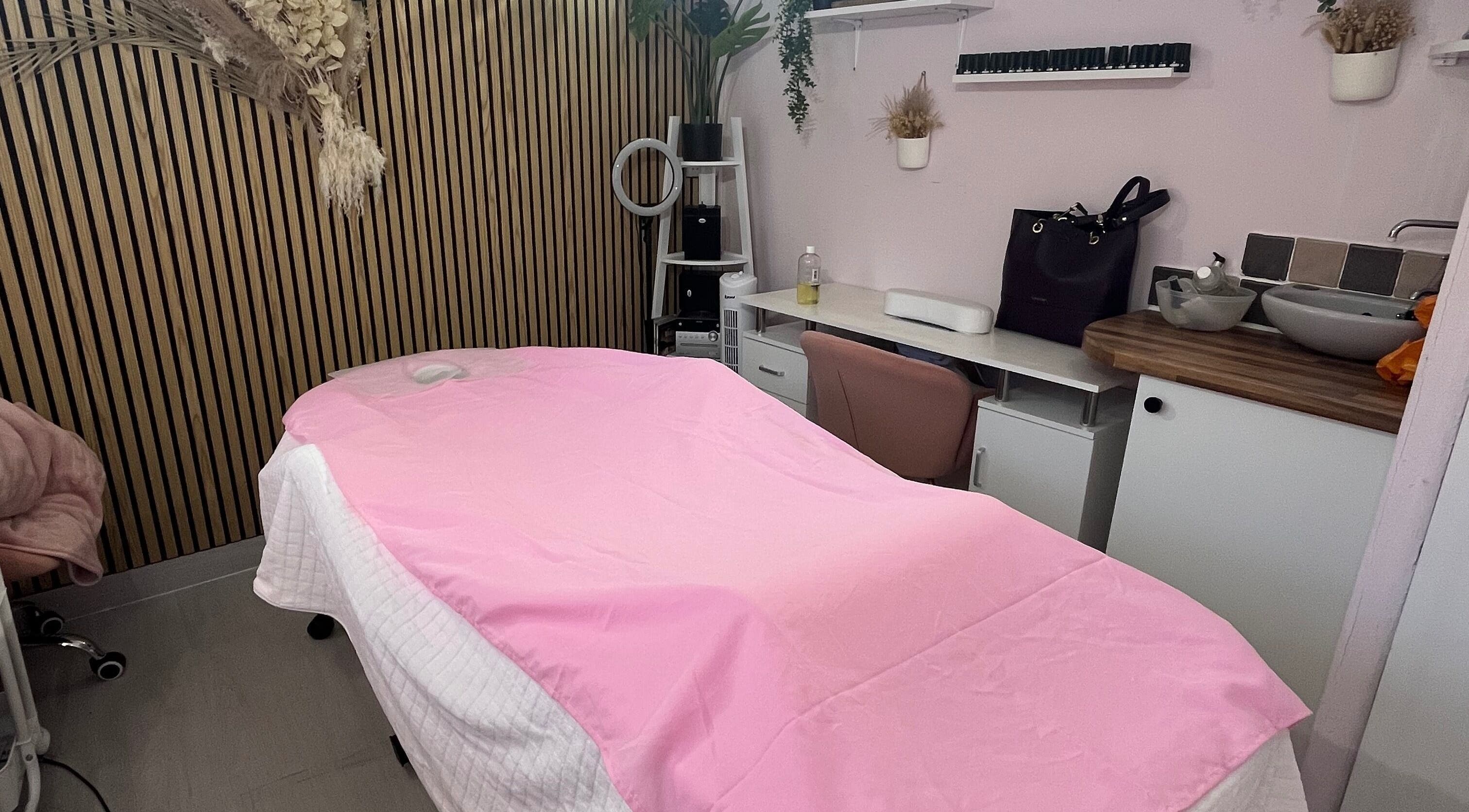 Peaceful massage room at Madame Massage, Portsmouth, England, GB, with pink decor and relaxing ambiance.