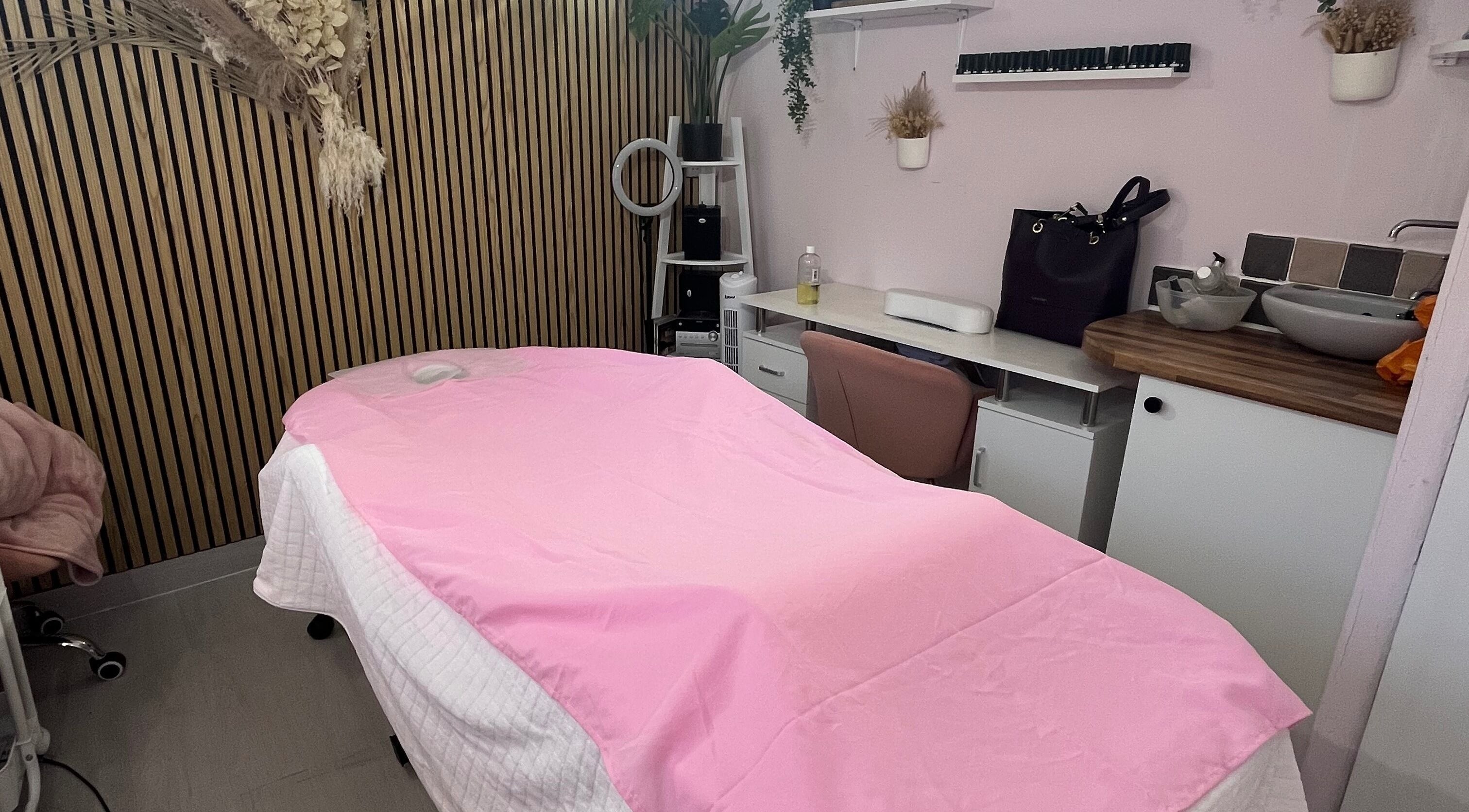 Peaceful massage room at Madame Massage, Portsmouth, England, GB, with pink decor and relaxing ambiance.