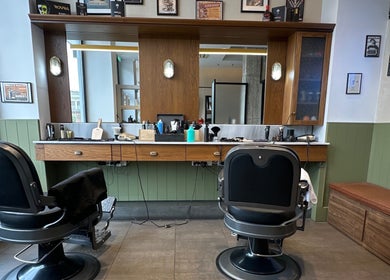 Εσωτερικό του Blade Barbershop Skg στην Ευκαρπία, GR με καρέκλες κουρέα και εργαλεία περιποίησης.