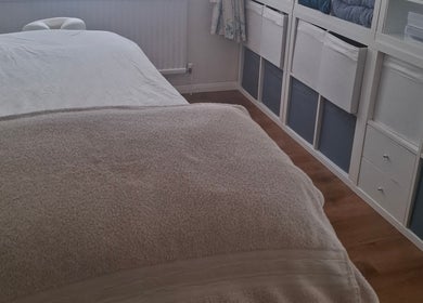 Tranquil massage room at Just Natural Therapies, Poole, England, GB with cozy spa bed and soft lighting.
