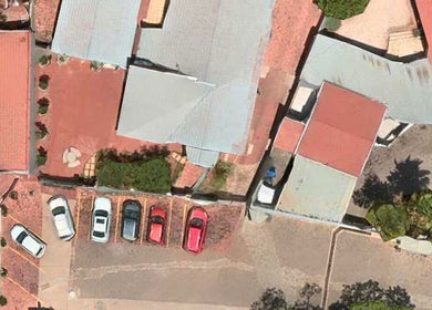 Aerial view of The Glow Room, Pretoria, Gauteng, ZA, featuring parking lot and building layout.