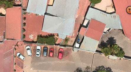 Aerial view of The Glow Room, Pretoria, Gauteng, ZA, featuring parking lot and building layout.