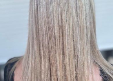 Cheveux blonds brillants coiffés chez Coiffureloww en FR, révélant une finesse et éclat exceptionnels.