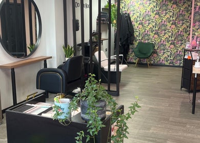 Modern salon interior at The Dollshouse Hair By Nat, Shortheath, England, GB with floral walls and stylish seating.