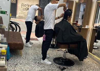 Barberos en acción en TÚ MEJOR VERSIÓN, Bogotá, Bogotá, CO, ofreciendo cortes de cabello modernos.