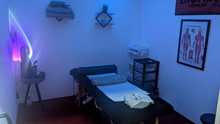 A serene massage room at Allison Grace Sports Massage, Oldham, England, GB, with calming blue lighting.