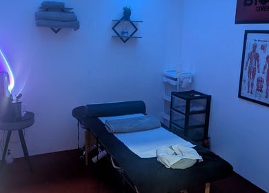 A serene massage room at Allison Grace Sports Massage, Oldham, England, GB, with calming blue lighting.