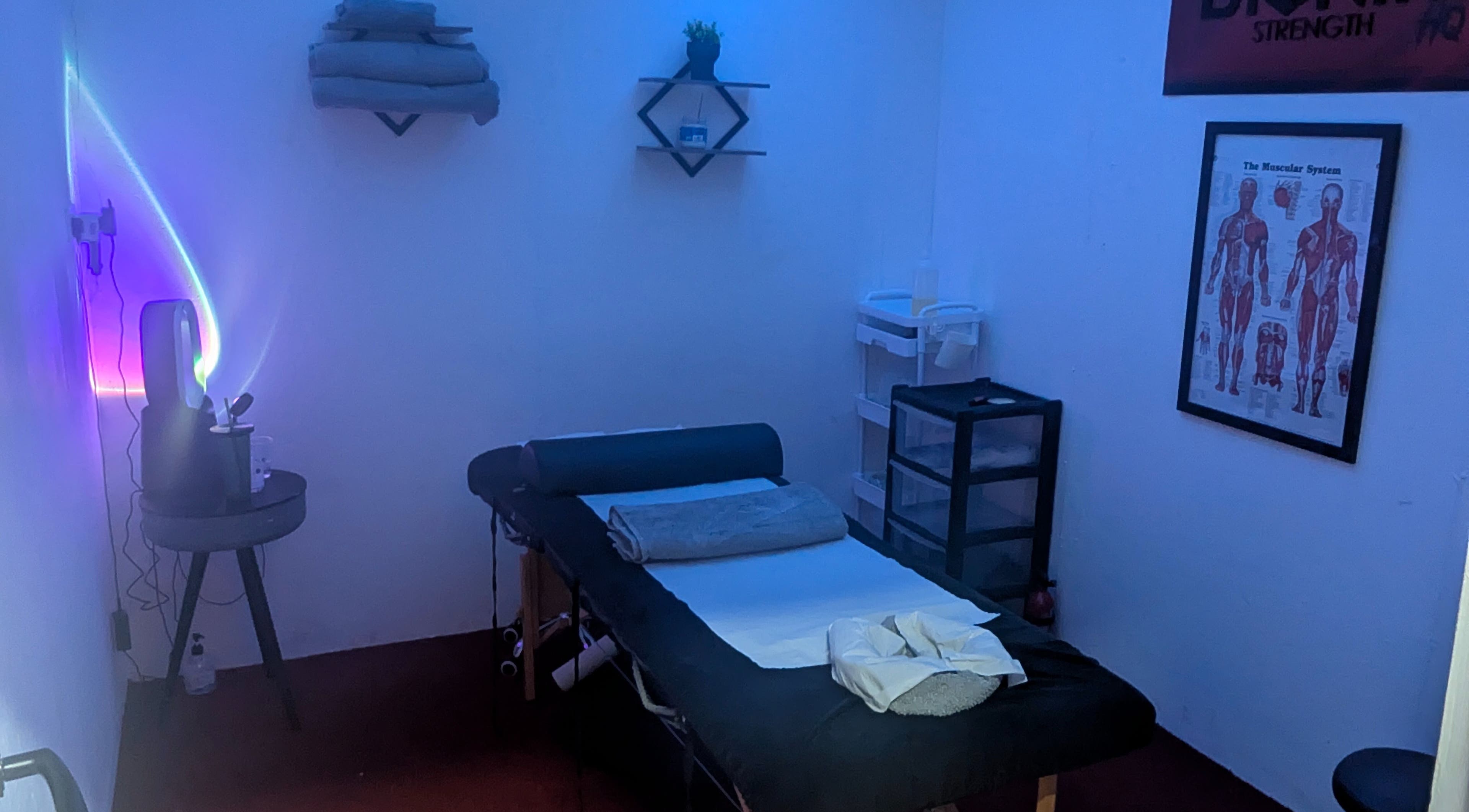 A serene massage room at Allison Grace Sports Massage, Oldham, England, GB, with calming blue lighting.