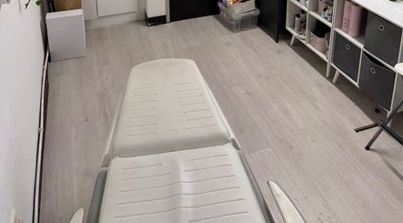 Therapy room at Allison Grace Sports Massage Therapist in Skelmersdale, England, GB. White table, organized shelves.