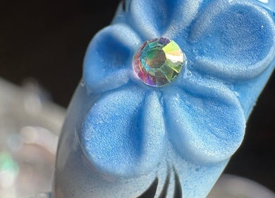 Uña con diseño floral azul y piedra brillante en Bymarietperez, Orlando, Florida, US.