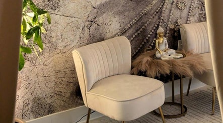 Cozy seating at Tranquil Touch Spa in Atlanta, Georgia, US, featuring plush chairs and a calming Buddha statue.