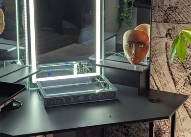 Modern makeup station at Tranquil Touch Spa, Atlanta, Georgia, US with illuminated mirror and decorative face mask.