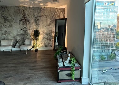 Relaxing lounge area at Tranquil Touch Spa in Atlanta, Georgia, US, featuring Buddha mural and city view.